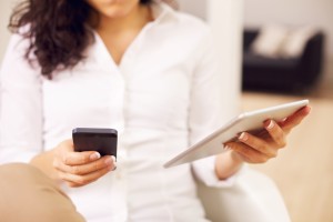 5 Reasons Your Small Business Internet Marketing Strategy Should Include Social Media Woman Deep Into Social Media Is Holding Mobile Phone In One Hand And iPad In The Other